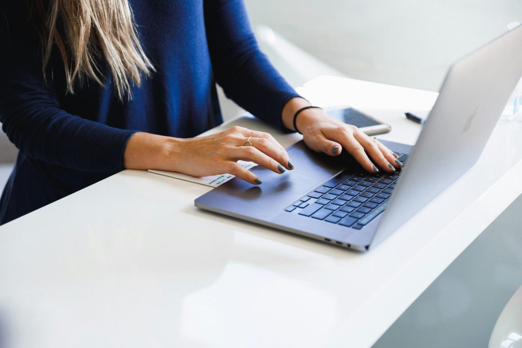 Mujer con camisa azul de manga larga usando MacBook Pro